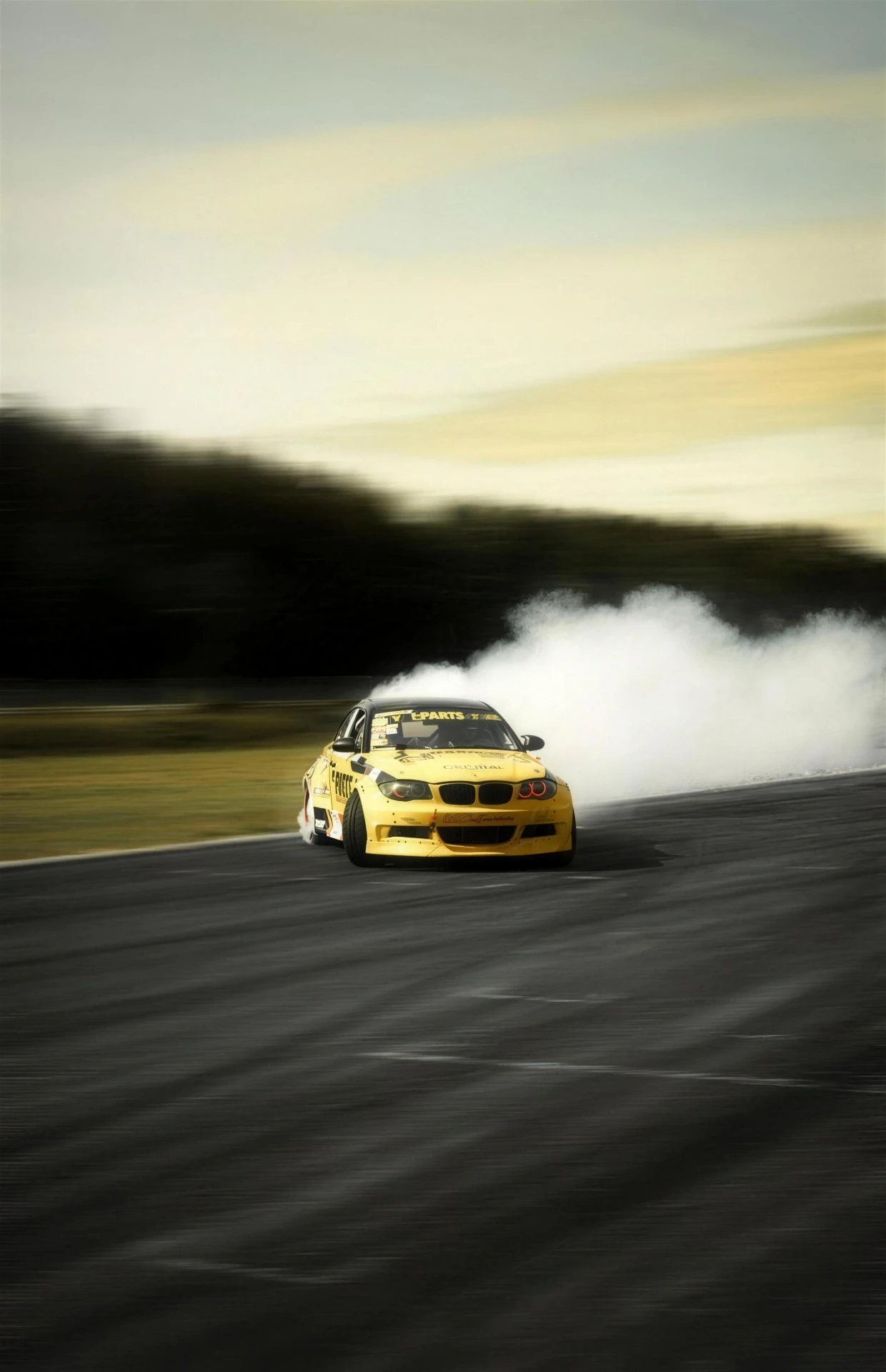 Gul BMW driftar i rök